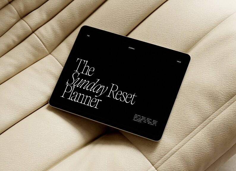 K&ouml;nnte beinhalten: Ein schwarzes Tablet-Computer mit einem wei&szlig;en Bildschirm, auf dem der Text "The Sunday Reset Planner" angezeigt wird.
