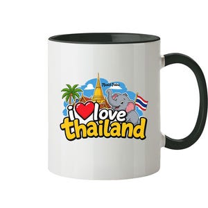 Può includere: Tazza in ceramica bianca con interno e manico neri. La tazza presenta una grafica colorata con la scritta "i love thailand", un cuore rosso, un elefante e la bandiera thailandese.