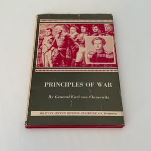 May include: A green book with a red spine and a red cover image of a group of men in military uniforms. The book title is "Principles of War" by General Carl von Clausewitz. The book is published by Military Service Division-Stackpole Co., Harrisburg.