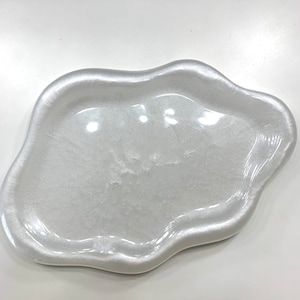 Op de afbeelding: Een parelmoerwit decoratief dienblad met een organische, wolkvormige vorm. De tray heeft een glanzende afwerking en een opstaande rand. Het is ontworpen om kleine items in te bewaren.