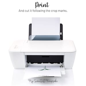 Op de afbeelding: Een witte printer met een vel papier dat wordt afgedrukt. Het papier heeft een groen ontwerp en de tekst "My Sweetest Keepsake". De tekst "Print" staat boven de printer en de tekst "En knip het uit langs de snijmarkeringen." staat onder de printer.