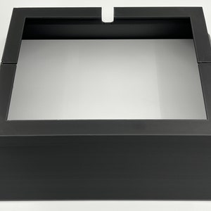May include: Black metal fireplace insert with a square opening and a raised base.