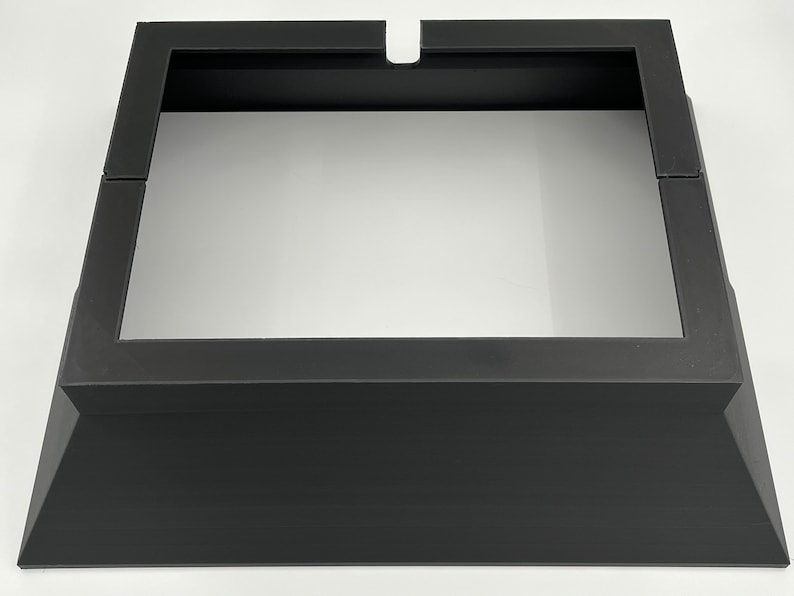 May include: Black metal fireplace insert with a square opening and a raised base.