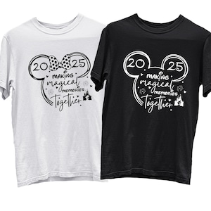 以下が含まれることがあります： 白と黒の2枚のTシャツで、ミッキーマウスのシルエットデザインが施されています。デザインには、20年と25年、そして「Making Magical Memories Together」という文字と、ミッキーの頭にリボンが描かれています。