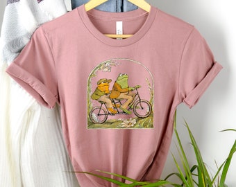 カエルとヒキガエルのシャツ、かわいいカエルのシャツ、カエルとヒキガエルのユニセックスTシャツ、ヴィンテージクラシックブック、コテージコア美学、本好きのTシャツ