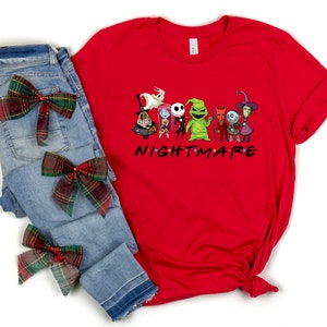 May include: Red t-shirt featuring a graphic of characters from the Nightmare Before Christmas film. The characters are arranged in a line with the text "NIGHTMARE" underneath. The shirt is styled with blue jeans and red and green plaid bows.