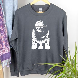 May include: Black sweatshirt with a white silhouette of the Death Star from Star Wars. The Death Star is depicted as a forest with a moon in the background.