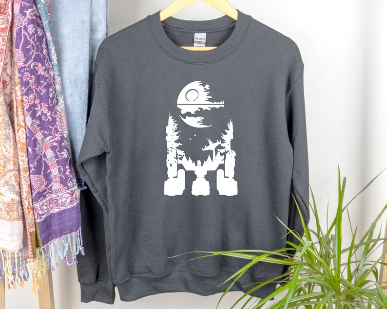 May include: Black sweatshirt with a white silhouette of the Death Star from Star Wars. The Death Star is depicted as a forest with a moon in the background.