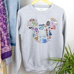 May include: Grey sweatshirt with a Mickey Mouse-shaped design featuring various Disney park icons, including the Spaceship Earth, Cinderella's Castle, and the Haunted Mansion.