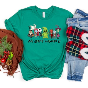 May include: A green t-shirt featuring a graphic of characters from the film "The Nightmare Before Christmas" and the text "NIGHTMARE" in a font similar to the "Friends" logo.