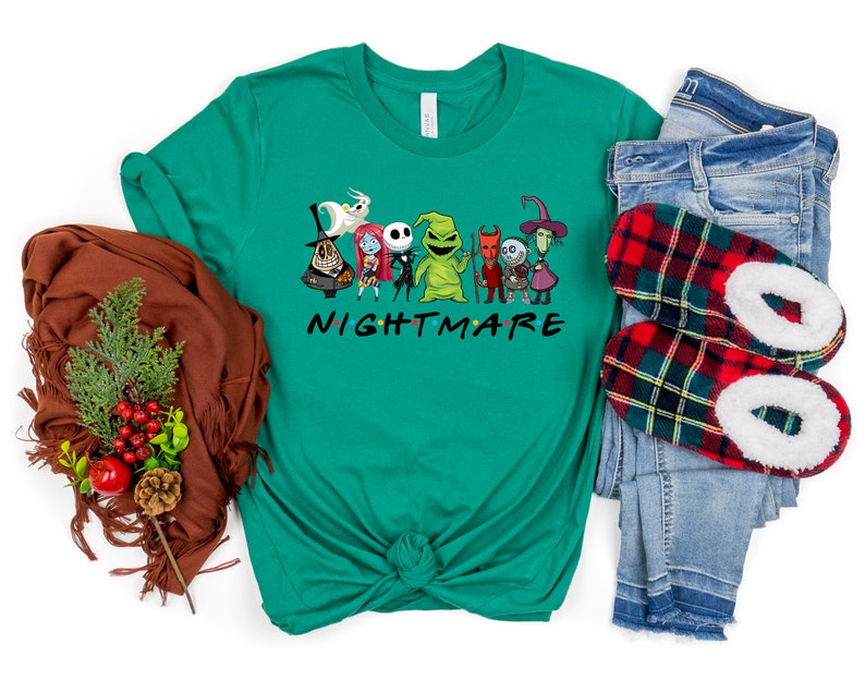 May include: A green t-shirt featuring a graphic of characters from the film "The Nightmare Before Christmas" and the text "NIGHTMARE" in a font similar to the "Friends" logo.