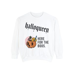 May include: White long-sleeved sweatshirt with the text "halloqueen" in black gothic font and a cartoon illustration of a skull-shaped coconut drink with a pineapple and umbrella. The text "HERE FOR THE BOOS." is below the illustration.