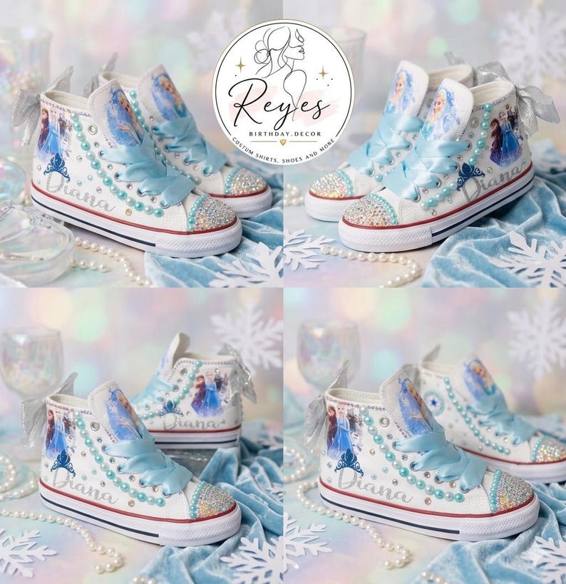 May include: White high-top sneakers featuring light blue satin ribbon laces, pearl accents, and a graphic print of animated characters. The shoes are personalized with the name Diana in script, silver bows at the heels, and crystal-embellished toes.