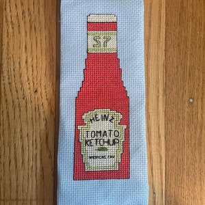 May include: A red and white Heinz Tomato Ketchup bottle with a yellow label and the text "America's Fav" on a blue background.