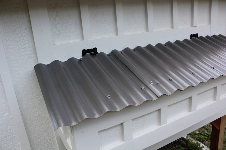 A close up of the chicken coop nesting box with a grey polycarbonate roof keeping the chickens dry