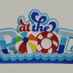 Pode incluir: Uma arte de papel azul e branco com as palavras "at the Pool" em letras brancas. A arte apresenta um salva-vidas vermelho e branco e uma bola de praia colorida.