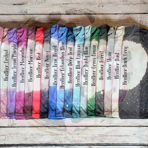 Puede incluir: Una selección de 18 camisetas en varios colores jaspeado, incluyendo amarillo oro, malva, orquídea, morado de equipo, magenta, granate, rojo, azul marino, azul real, azul Columbia, azul teal oscuro, azul laguna, azul polvoriento, verde hierba, bosque, piedra, polvo y gris oscuro.