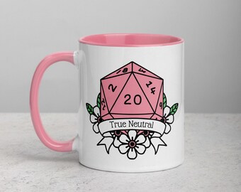 May include: White ceramic mug with a pink interior and handle. The mug features a pink, twenty-sided die design with the text "True Neutral" on a banner, surrounded by floral accents. A fun gift for tabletop gamers.