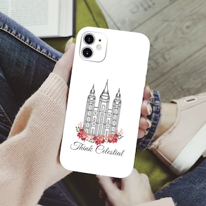 May include: White phone case with a black outline of a temple and floral design. The text "Think Celestial" is printed below the temple.