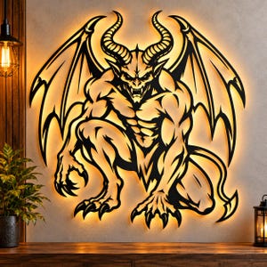 May include: A black metal wall art piece depicting a winged demon with horns, sharp claws, and a muscular physique. The cutout design is backlit with a warm golden glow, creating a silhouette effect against the wall surface.