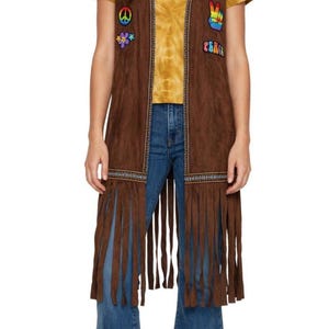 May include: A brown sleeveless vest featuring long fringe at the hem, decorative trim along the front edges, and colorful embroidered patches including a peace sign, a flower, a hand making a peace gesture, and the word PEACE in block letters.