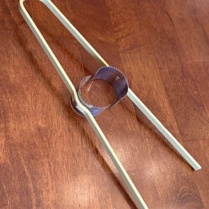 Könnte beinhalten: Ein weißer Eischneider aus Kunststoff mit einem Edelstahl-Schneide-Ring. Der Eischneider ist so konzipiert, dass er hartgekochte Eier in gleichmäßige Scheiben schneidet.