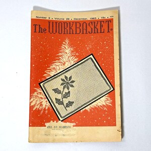 May include: A vintage copy of "The Workbasket" magazine from December 1963. The cover is orange with a white Christmas tree and a floral embroidery design. The magazine's title and issue details are printed at the top, with the price.