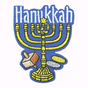 May include: A blue embroidered patch with the word "Hanukkah" in white lettering. A gold menorah with nine candles is in the center of the patch. A dreidel and a plate of latkes are at the bottom of the patch.