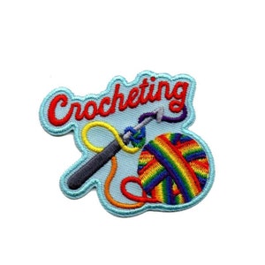 May include: Crocheting embroidered patch featuring a rainbow yarn ball and a crochet hook. The text "Crocheting" is in red.