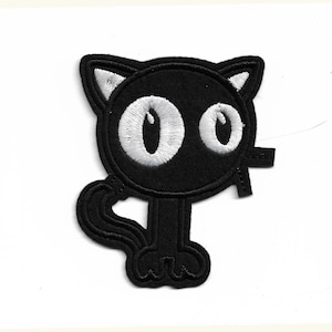 May include: Black felt iron-on patch of a cartoon cat with white eyes and a tail.