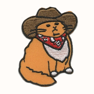 Peut inclure: Patch brodé représentant un chat brun portant un chapeau de cowboy brun et un bandana rouge avec une bordure blanche. Le chat est assis, la queue enroulée derrière lui.