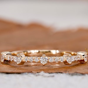 May include: A delicate gold band ring with a row of small diamonds and three larger diamonds in the centre.