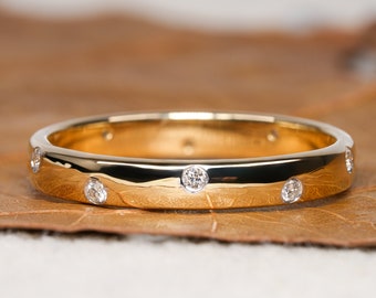 May include: A gold band with a polished finish and six small round diamonds set into the band.