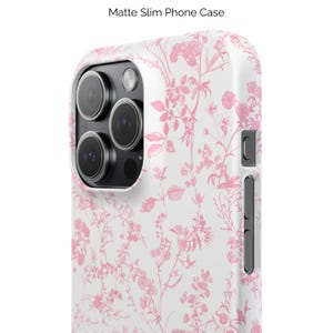 Pode incluir: Uma capa de telefone branca com um padr&atilde;o floral rosa. A capa tem um acabamento fosco e um design fino.  "Matte Slim Phone Case" est&aacute; impresso no topo da imagem.