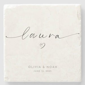 Puede incluir: Posavasos cuadrado de mármol blanquecino con el nombre "laura" en escritura cursiva, un pequeño corazón y los nombres "OLIVIA & NOAH" con la fecha "JUNE 12, 2025" impresos debajo. El posavasos tiene una superficie texturizada.