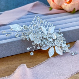 Elegant silver finish hair accessory adorned with lustrous flowers and leaves - the perfect complement for a graceful and refined hairstyle.