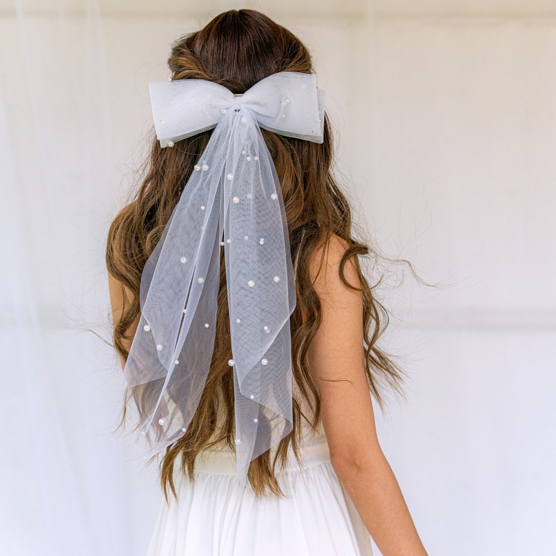 Large Pearl Bow Veil foe Bride. Celebrate the bride-to-be in style at the bachelor party with the 2024 Trendy Bow Veil – a versatile wedding hairpiece that serves as a perfect pre-wedding gift for bridal showers.