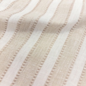 May include: A woven fabric featuring a repeating pattern of vertical stripes in alternating shades of beige and white. The texture includes subtle raised dotted lines running parallel to the stripes, creating a tactile surface with a soft, natural appearance.
