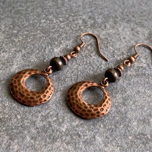 Hanging earrings made of hammered copper and wooden and metal beads