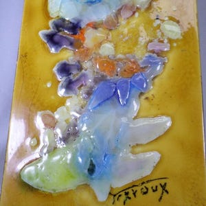 Könnte beinhalten: Rechteckige Keramikfliese mit strukturiertem gelbem Hintergrund. Die Fliese zeigt ein farbenfrohes abstraktes Design mit blauen, lila, orangefarbenen und weißen Formen. Die Signatur des Künstlers, "Tréroux", ist in schwarzer Tinte.