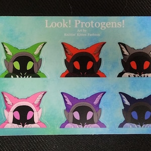 May include: A sheet of stickers featuring six stylized Protogen characters in various colors. The characters have cat-like ears and visors, with colors including green, red, gray, pink, purple, and blue. Text at the top reads "Look! Protogens!"