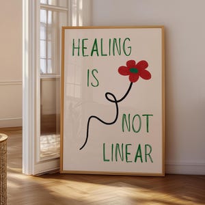 Może przedstawiać: Oprawiony wydruk artystyczny na jasnobeżowym tle z zielonym napisem HEALING IS NOT LINEAR. Czerwony kwiat z zielonym środkiem jest przymocowany do czarnej, spiralnej, nieliniowej łodygi, która wije się pomiędzy tekstem na plakacie.