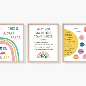 Pode incluir: Tr&ecirc;s cartazes coloridos com designs de arco-&iacute;ris e texto. O primeiro cartaz diz "Este &eacute; um espa&ccedil;o seguro para ser quem voc&ecirc; &eacute;". O segundo cartaz diz "O que voc&ecirc; diz aqui fica aqui - a menos que - 1. Algu&eacute;m esteja te machucando 2. Voc&ecirc; queira machucar outra pessoa 3. Voc&ecirc; queira se machucar 4. Voc&ecirc; me d&ecirc; permiss&atilde;o para compartilhar". O terceiro cartaz diz "Eu posso controlar: Meus pensamentos, Meus limites, As escolhas que fa&ccedil;o, Minhas a&ccedil;&otilde;es, A maneira como trato os outros, Como respondo, Meus valores, Minha atitude, Amar a mim mesmo, Minhas palavras. Eu n&atilde;o posso controlar: O comportamento dos outros, Os sentimentos dos outros, Meu passado, O clima, A resposta dos outros, O que acontece ao meu redor, O que os outros pensam, As a&ccedil;&otilde;es dos outros, Os erros que os outros cometem".
