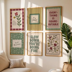 May include: A collection of six framed art prints with inspirational quotes and floral designs. The prints feature various color schemes, including green, red, and beige, and are arranged on a white wall. The frames are a light wood color, and the overall aesthetic is modern and uplifting.
