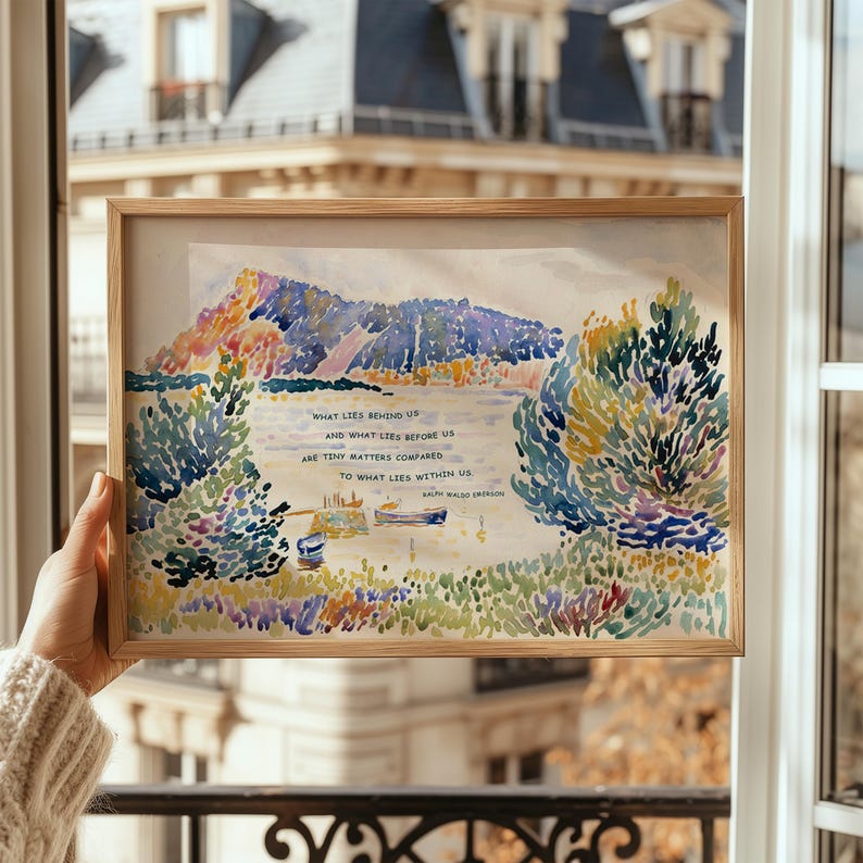Puede incluir: Una impresi&oacute;n en acuarela enmarcada que representa un paisaje lacustre con &aacute;rboles coloridos, monta&ntilde;as y botes. La obra de arte incluye la cita: "Lo que hay detr&aacute;s de nosotros y lo que hay delante de nosotros son asuntos insignificantes en comparaci&oacute;n con lo que hay dentro de nosotros". El marco es de madera clara.