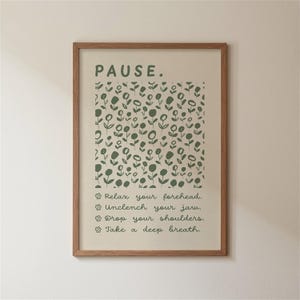 May include: A framed print with the word "PAUSE" in green above a floral pattern. Below, the print lists steps for relaxation: "Relax your forehead," "Unclench your jaw," "Drop your shoulders," and "Take a deep breath."