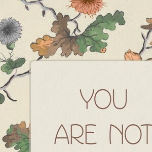 May include: A beige background with a floral pattern in shades of green, brown, and pink. The text "YOU ARE NOT" is written in brown on a white rectangle.