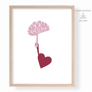 Puede incluir: Un &aacute;rbol en forma de cerebro rosa es sostenido por una mano con un coraz&oacute;n rojo en la parte inferior. La imagen est&aacute; en un marco de madera claro.
