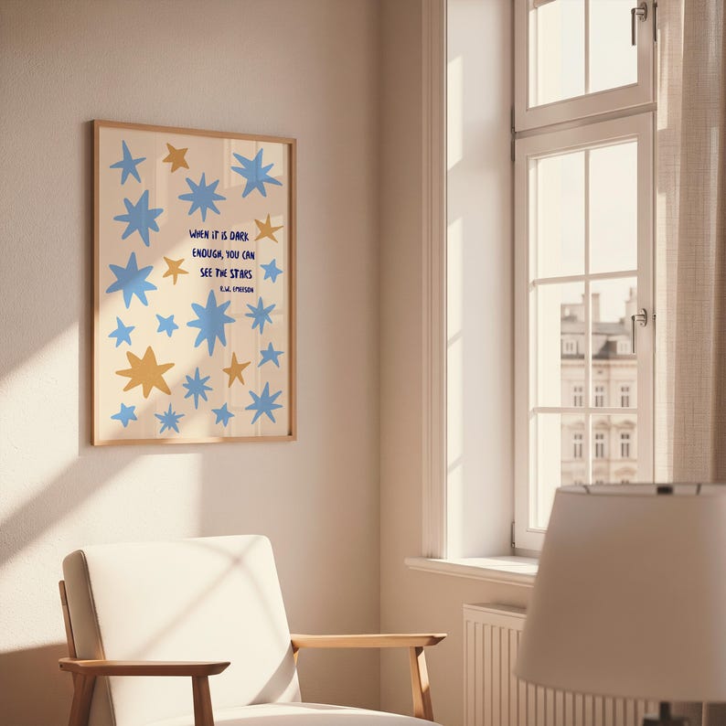 May include: A framed art print featuring a cream-colored background with blue and gold star shapes. The print includes the quote "WHEN IT IS DARK ENOUGH, YOU CAN SEE THE STARS" in blue text, attributed to E.L. Epstein.