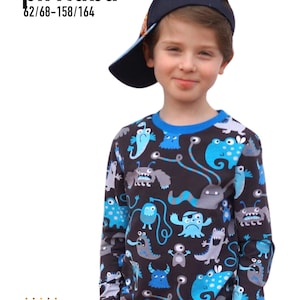 Könnte beinhalten: Ein langärmeliges Shirt mit einem blau-schwarzen Monstermuster. Das Shirt hat einen blauen Kragen und Bündchen. Das Bild zeigt auch eine marineblaue Baseballkappe. Der Text "pirituba" und "62/68-158/164" sind sichtbar.